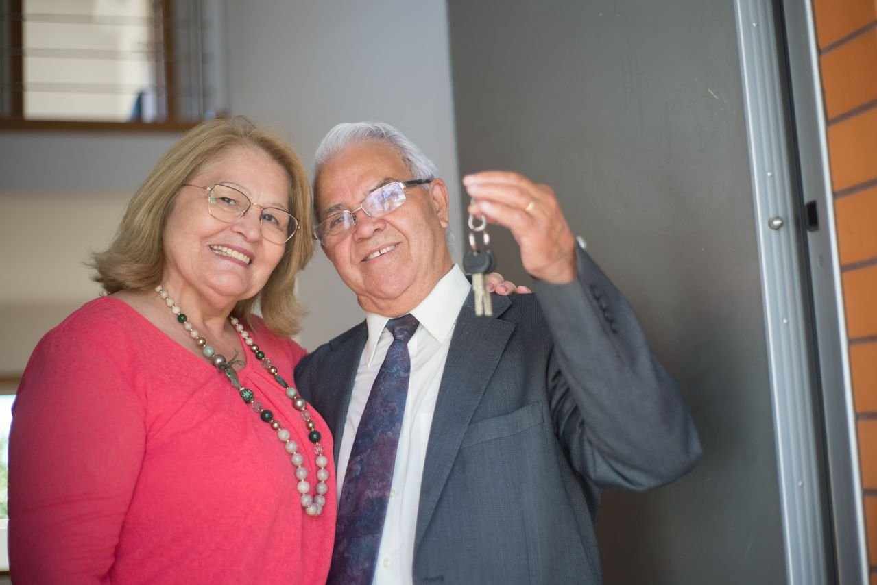 Senior homeowner holding house keys, exploring reverse mortgage options at age 62 or older